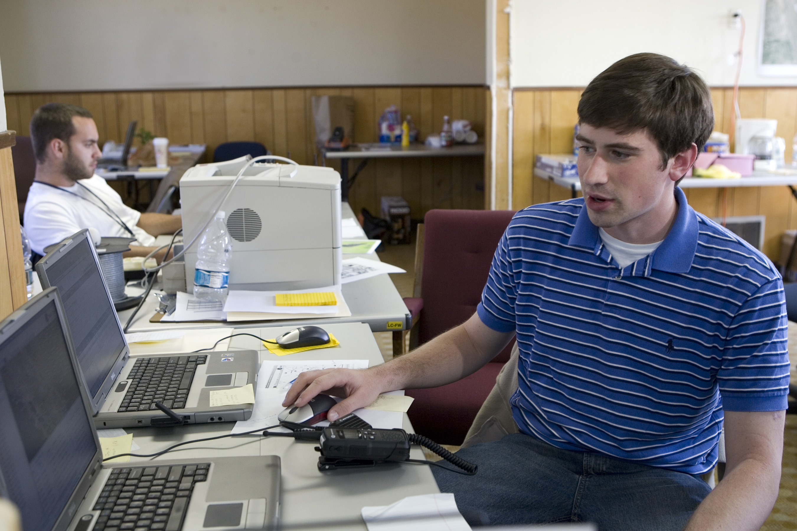 FEMA contractor working at a computer while monitoring housing progress