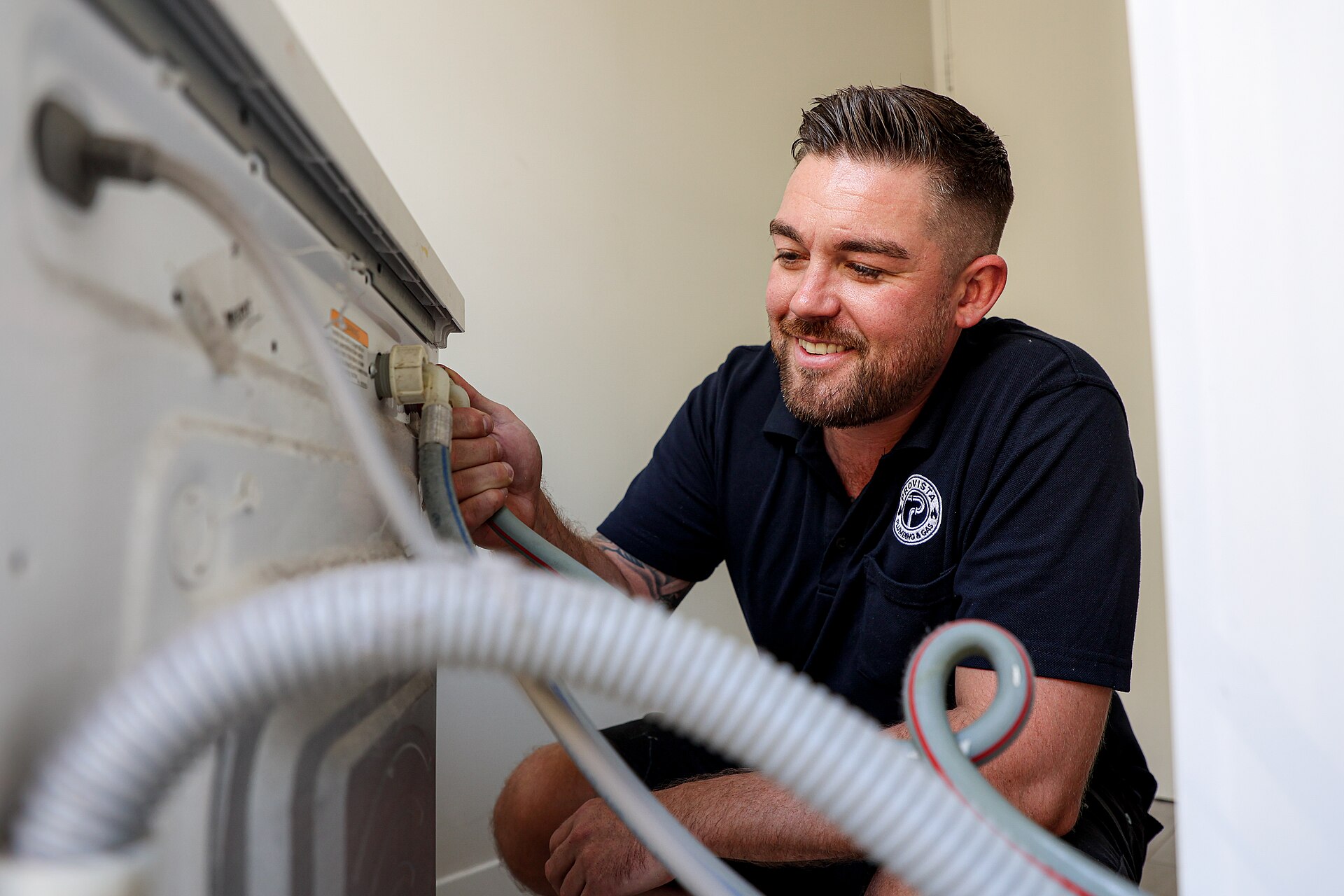 Plumber repairing a residential appliance connection on site